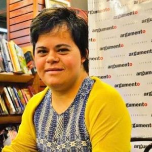 Débora Seabra, primeira professora com síndrome de Down no Brasil, posa em uma livraria.