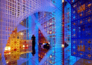Uma das salas da instalação "Além do infinito" de Serge Salat, montada sobre formas, cores e espelhos que dão a sensação de infinidade. No centro da instalação uma pessoa é reproduzida em infinitas imagens espelhadas.