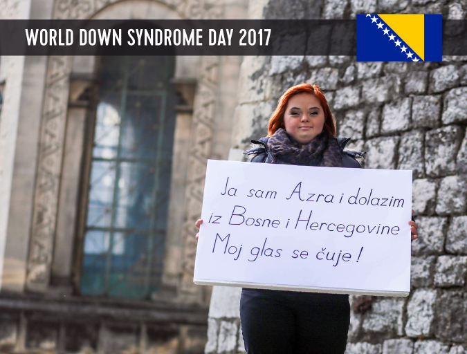Azra, moça com sindrome de Down da Bosnia, segura um cartaz. 