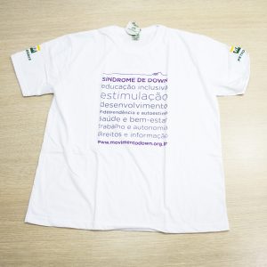 Camisa branca em malha ecológica com estampa de termos relacionados á inclusão e ao desenvolvimento.